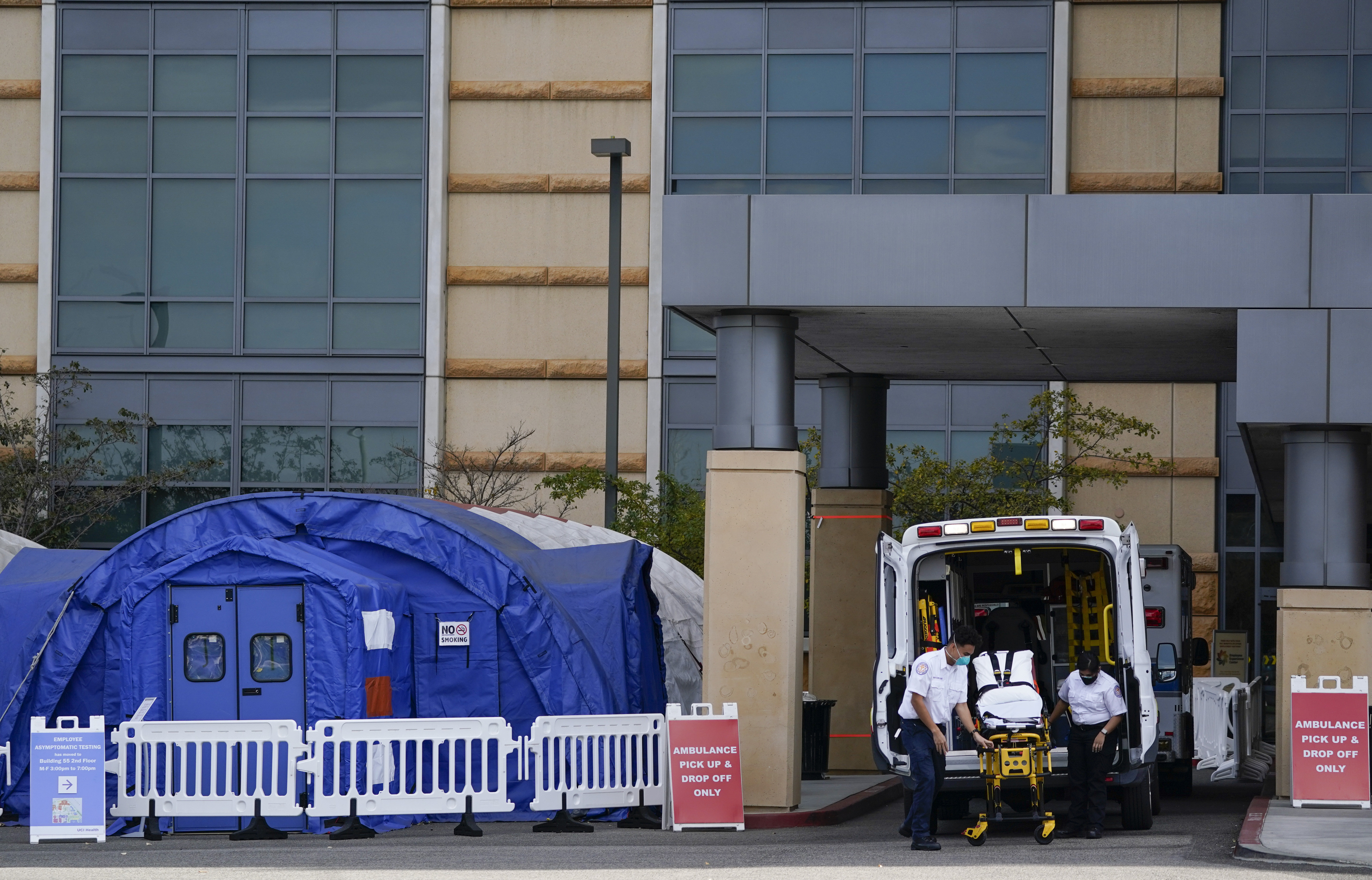 In this Dec. 17, 2020, file photo, medical workers remove a stretcher from an ambulance near medical tents outside the emergency room at UCI Medical Center, in Irvine, Calif. (Ashley Landis/AP Photo)