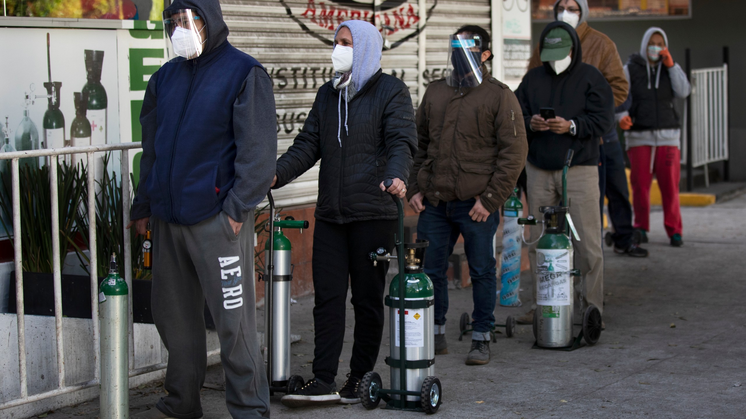 People line up with empty oxygen tanks to refill for family members sick with COVID-19 outside an oxygen store where dozens wait their turn in Mexico City, Thursday, Dec. 31, 2020. (Marco Ugarte/AP Photo)