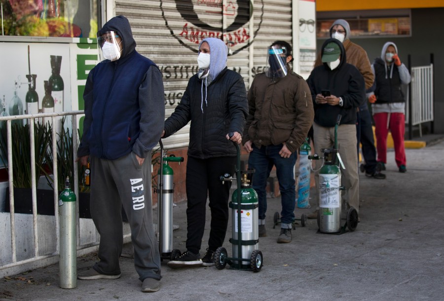 People line up with empty oxygen tanks to refill for family members sick with COVID-19 outside an oxygen store where dozens wait their turn in Mexico City, Thursday, Dec. 31, 2020. (Marco Ugarte/AP Photo)