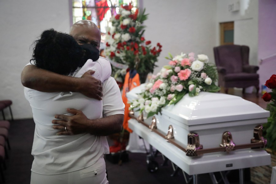 In this July 21, 2020, file photo, Darryl Hutchinson, facing camera, is hugged by a relative during a funeral service for Lydia Nunez, who was Hutchinson's cousin at the Metropolitan Baptist Church in Los Angeles. Nunez died from COVID-19. (AP Photo/Marcio Jose Sanchez, File)