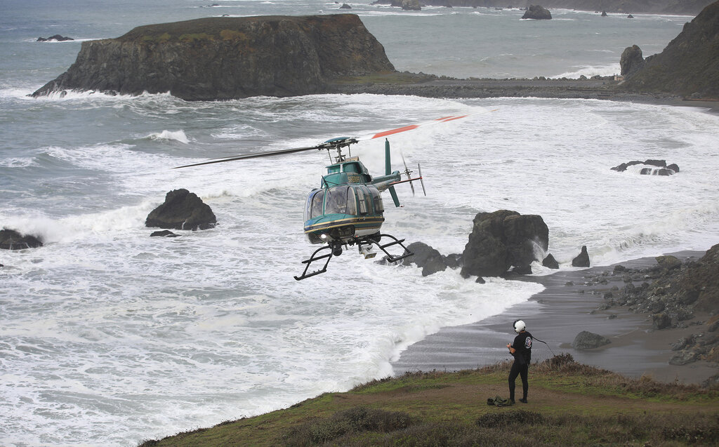 Henry 1, the Sonoma County, Calif., Sheriff's helicopter team, searches Monday, Jan. 4, 2021, for two missing children that were swept away in the surf at Blind Beach, right, that also killed their father Sunday afternoon near Jenner, Calif. (Kent Porter/The Press Democrat via AP)