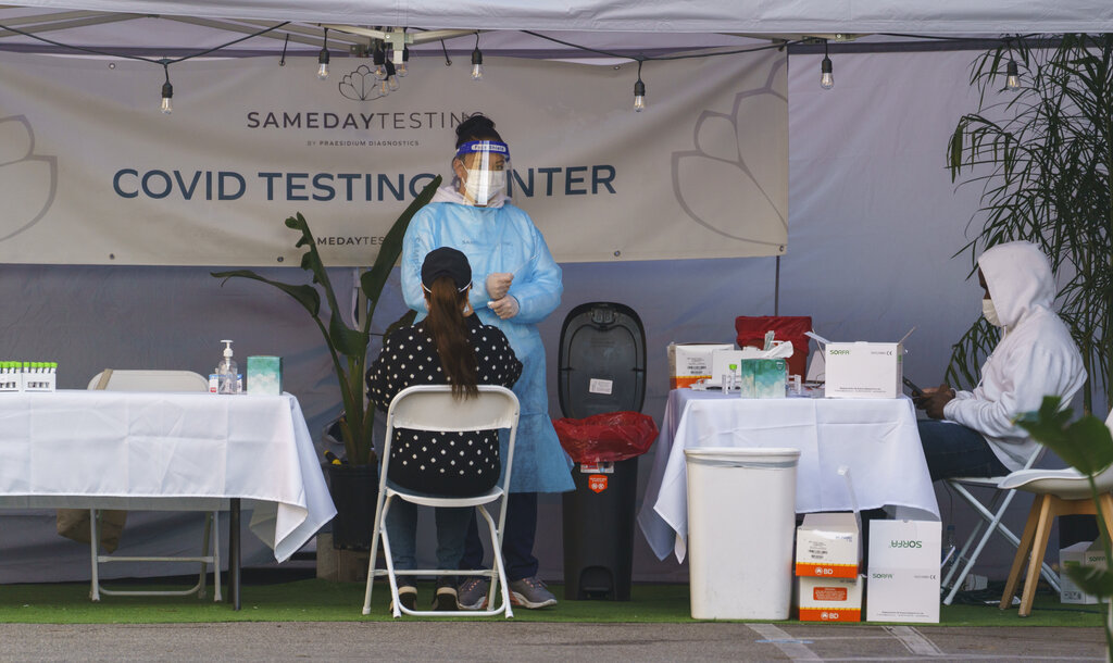 A mid-turbinate nasal swab PCR test is administered at a same-day coronavirus testing site in Los Angeles on Tuesday, Jan. 5, 2021. (AP Photo/Damian Dovarganes)