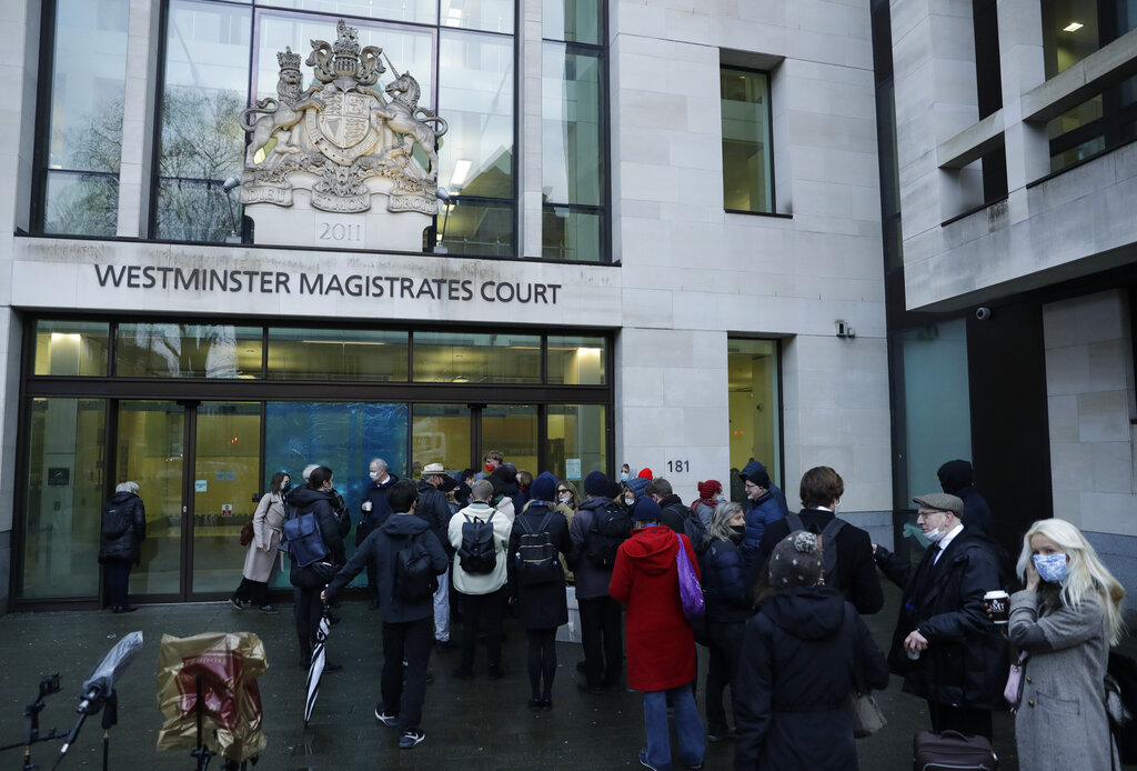 Julian Assange supporters and members of the media queue up outside Westminster Magistrates Court to get a seat at his Bail hearing in London, Wednesday, Jan. 6, 2021. (AP Photo/Matt Dunham)