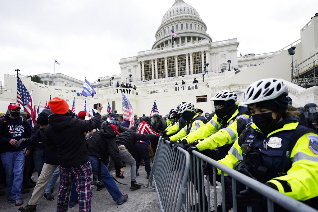 Trump supporters try to break through a police barrier, Wednesday, Jan. 6, 2021, at the Capitol in Washington. As Congress prepares to affirm President-elect Joe Biden's victory, thousands of people have gathered to show their support for President Donald Trump and his claims of election fraud. (AP Photo/Julio Cortez)