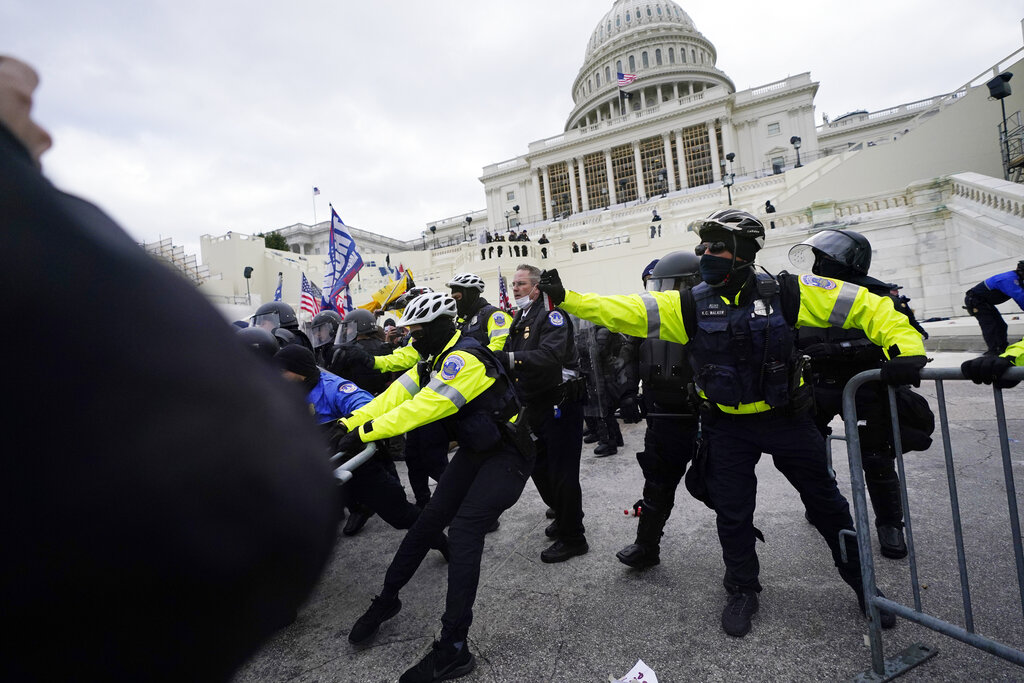 Trump supporters try to break through a police barrier, Wednesday, Jan. 6, 2021, at the Capitol in Washington. As Congress prepares to affirm President-elect Joe Biden's victory, thousands of people have gathered to show their support for President Donald Trump and his claims of election fraud. (AP Photo/Julio Cortez)