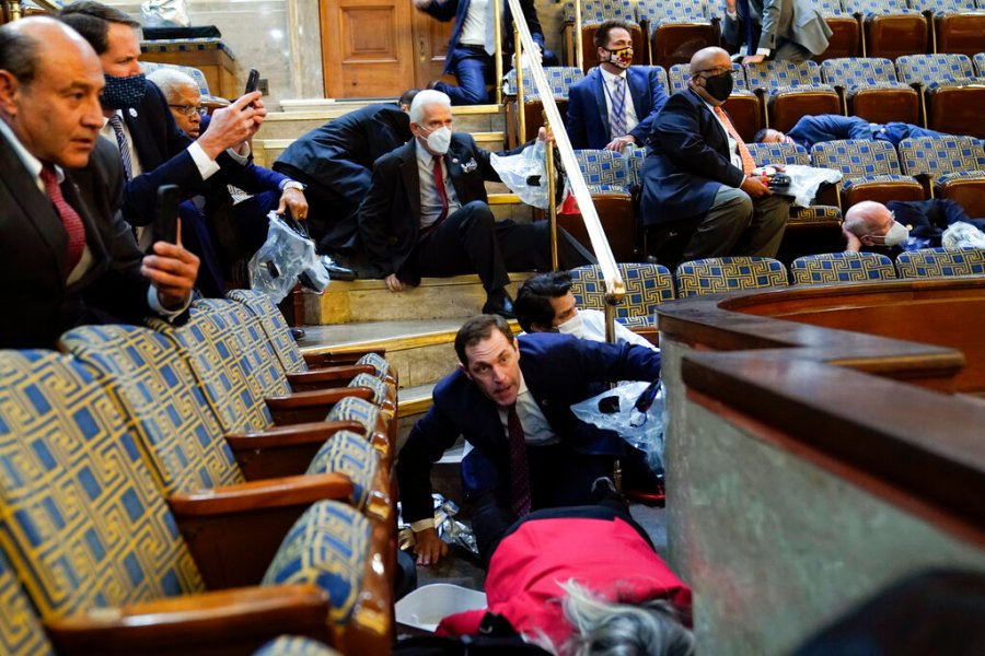 People shelter in the House gallery as protesters try to break into the House Chamber at the U.S. Capitol on Jan. 6, 2021, in Washington. (AP Photo/Andrew Harnik)