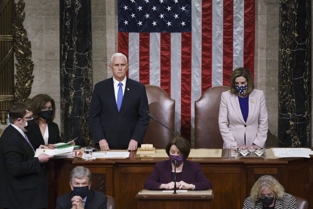 Vice President Mike Pence and Speaker of the House Nancy Pelosi, D-Calif., read the final certification of Electoral College votes cast in November's presidential election during a joint session of Congress after working through the night, at the Capitol in Washington, Thursday, Jan. 7, 2021. (AP Photo/J. Scott Applewhite, Pool)