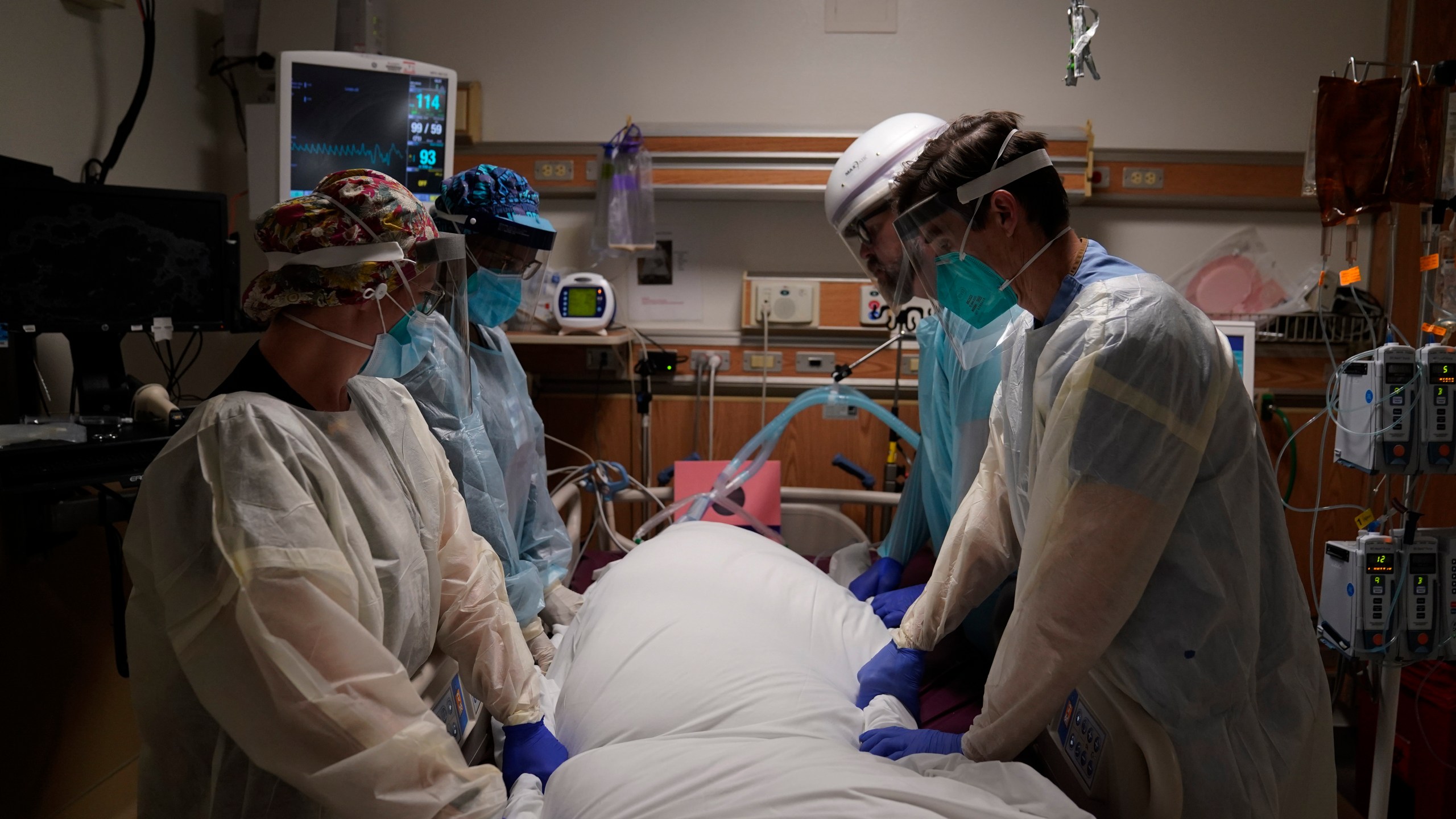 In this Dec. 22, 2020, file photo, medical workers prepare to manually prone a COVID-19 patient in an intensive care unit at Providence Holy Cross Medical Center in the Mission Hills section of Los Angeles. (AP Photo/Jae C. Hong)