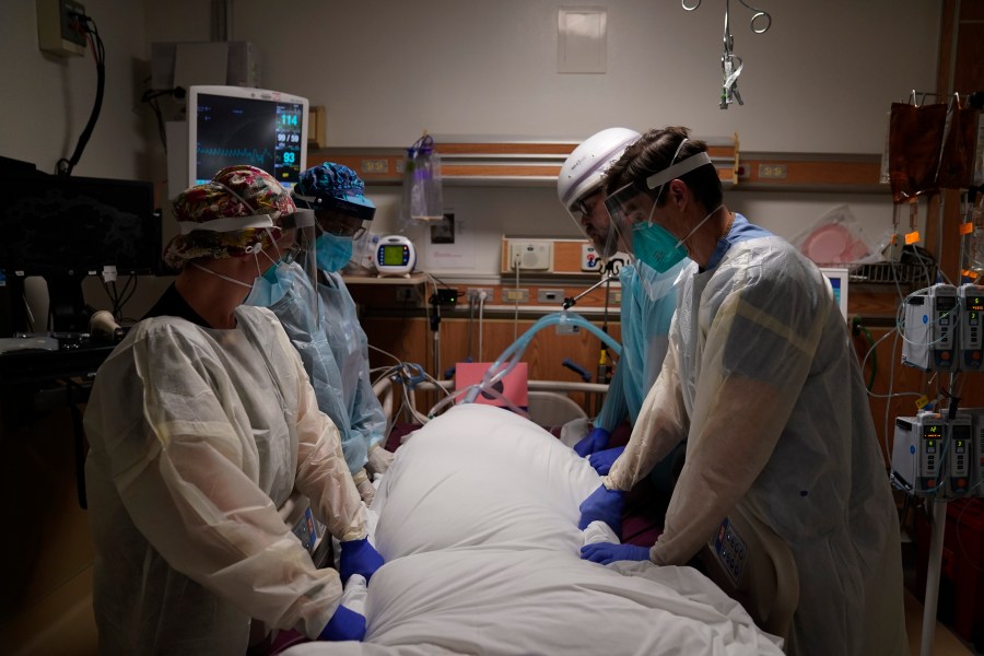 In this Dec. 22, 2020, file photo, medical workers prepare to manually prone a COVID-19 patient in an intensive care unit at Providence Holy Cross Medical Center in the Mission Hills section of Los Angeles. (AP Photo/Jae C. Hong)