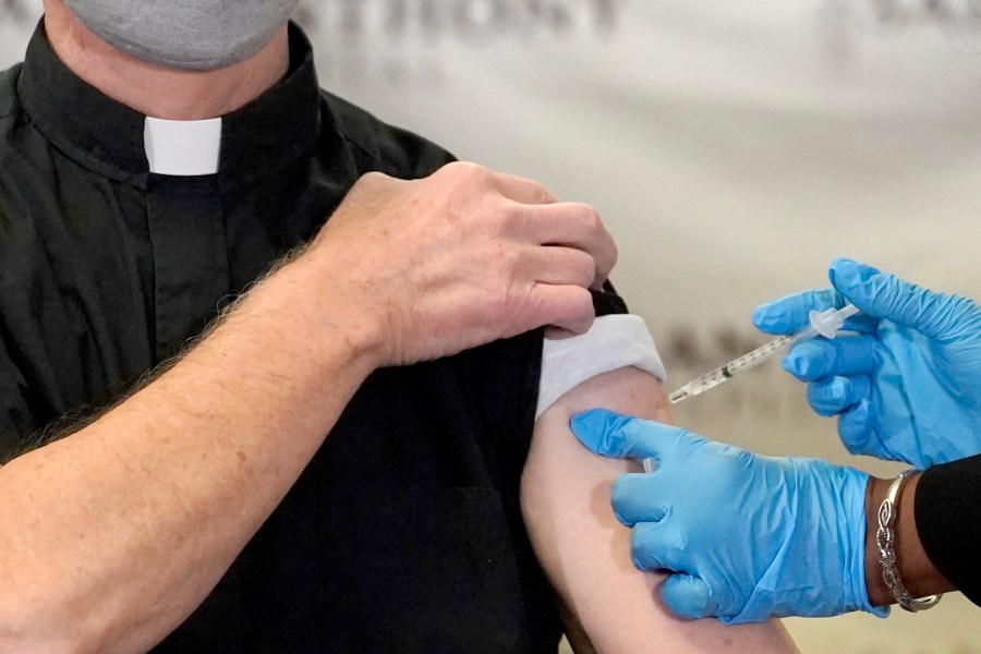 In this Wednesday, Dec. 23, 2020 file photo, a Catholic pastor receives the first of the two Pfizer-BioNTech COVID-19 vaccinations at a hospital in Chicago. (AP Photo/Charles Rex Arbogast)