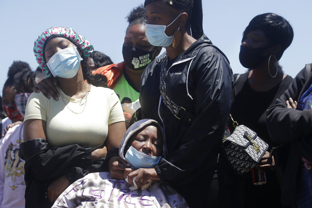 In this July 7, 2020, file photo, LaKesha Young, bottom, is comforted by others at a news conference in San Francisco, about the shooting death of her son, Jace Young. (AP Photo/Jeff Chiu, File)