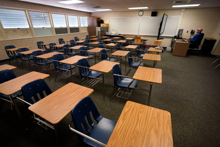 Math teacher Doug Walters sits among empty desks as he takes part in a video conference with other teachers to prepare for at-home learning at Twentynine Palms Junior High School in Twentynine Palms on Aug. 18, 2020. (Gregory Bull / Associated Press)