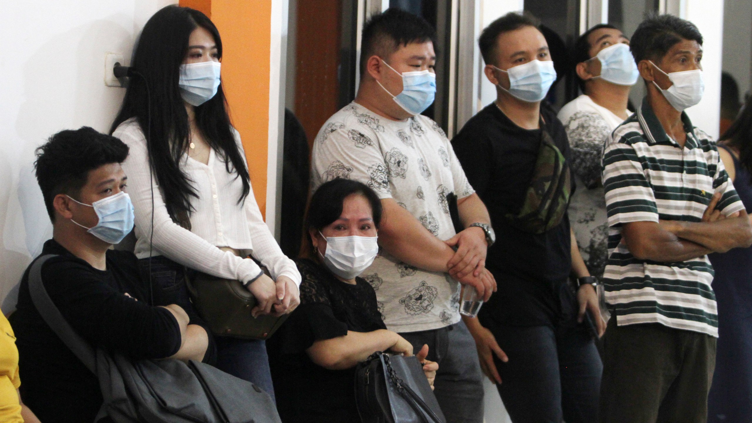 People wait for news on their relatives who are on board of Sriwijaya Air passenger jet that lost contact with air traffic controllers after take off, at Soepadio International Airport in Pontianak, West Kalimantan, Indonesia, Saturday, Jan. 9, 2021. (AP Photo/Helmansyah)