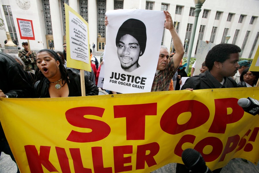 In this June 13, 2011, file photo protesters gather at the the U.S. District Court building in Los Angeles on behalf of shooting victim Oscar Grant. (AP Photo/Nick Ut, file)