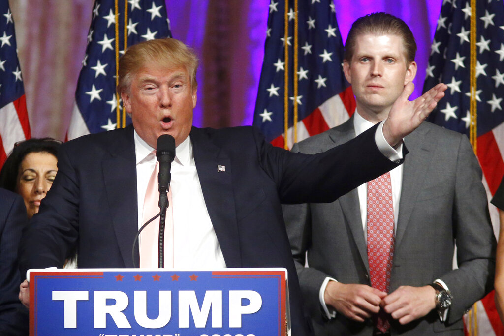 In this Tuesday, March 15, 2016, file photo, Republican presidential candidate Donald Trump speaks to supporters at his primary election night event at his Mar-a-Lago Club in Palm Beach, Fla. At right is his son Eric Trump. (AP Photo/Gerald Herbert, File)