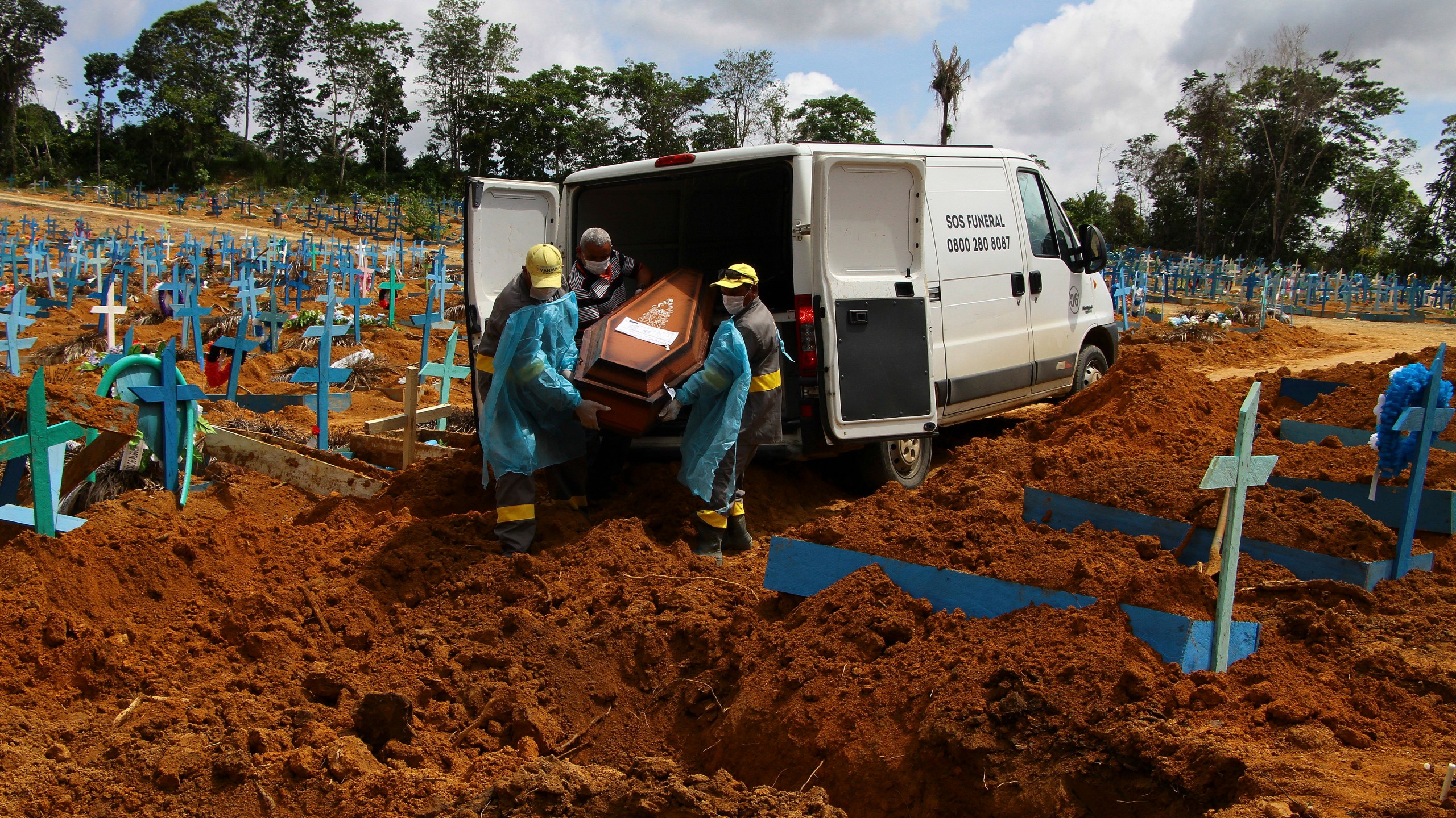 In this Jan. 6, 2021, file photo, cemetery workers carry the remains of 89-year-old Abilio Ribeiro, who died of the coronavirus, to bury at the Nossa Senhora Aparecida cemetery in Manaus, Amazonas state, Brazil. (AP Photo/Edmar Barros)