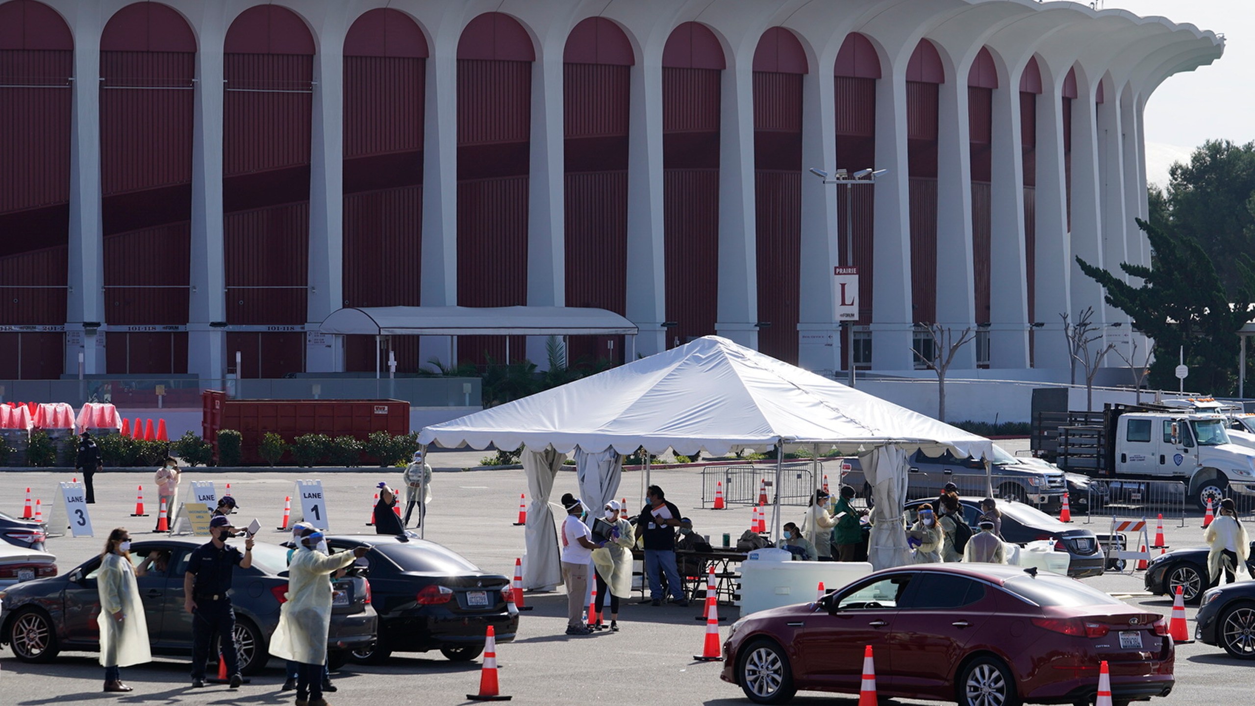 Drivers with vaccine appointments wait in line to register at a mass COVID-19 vaccination site outside The Forum in Inglewood on Jan. 19, 2021. (Damian Dovarganes / Associated Press)