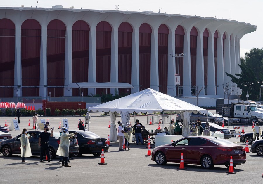 Drivers with vaccine appointments wait in line to register at a mass COVID-19 vaccination site outside The Forum in Inglewood on Jan. 19, 2021. (Damian Dovarganes / Associated Press)