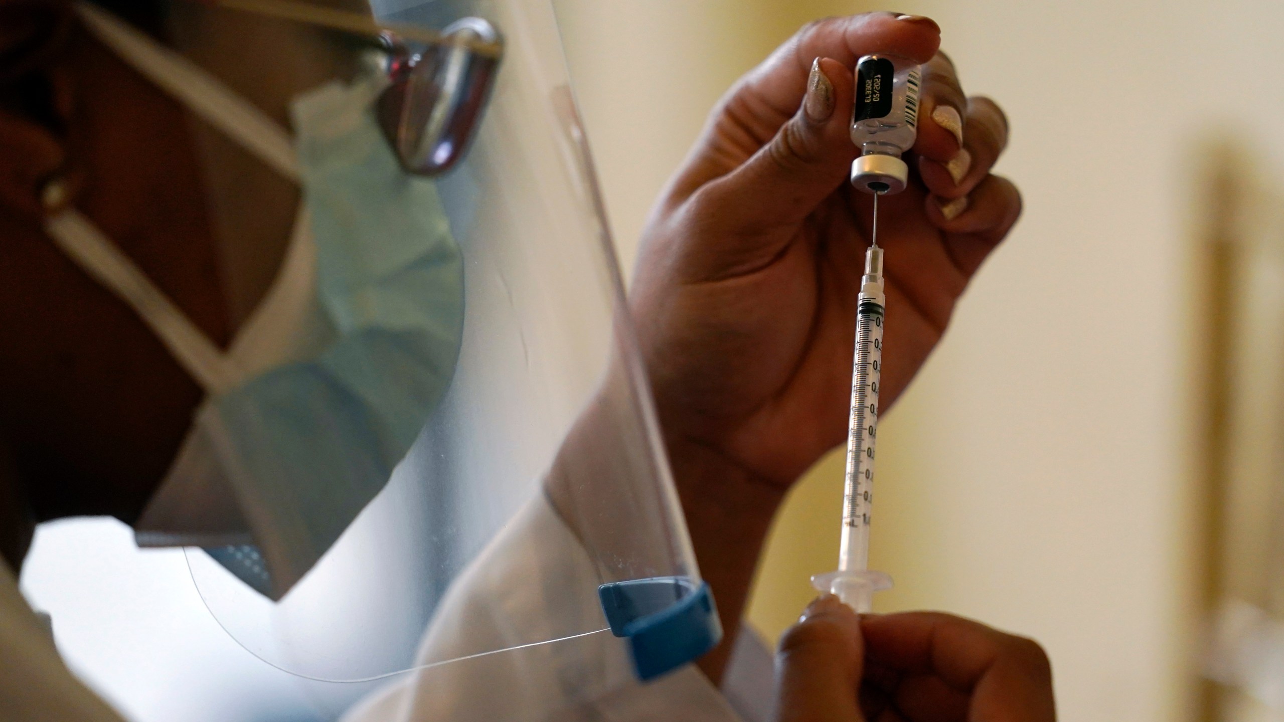 In this Tuesday, Jan. 12, 2021, file photo, a Walgreens pharmacist prepares a syringe with the Pfizer-BioNTech COVID-19 vaccine for residents and staff at the The Palace assisted living facility in Coral Gables, Fla. (AP Photo/Lynne Sladky)