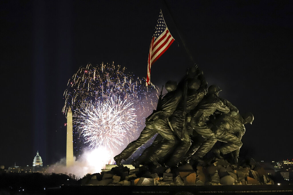 Fireworks explode over the Washington Monument with the Marine Corps War Memorial in the foreground, Wednesday, Jan. 20, 2021, in Arlington, Va., as part of the festivities after President Joe Biden was inaugurated as the 46th president of the United States. (AP Photo/Shafkat Anowar)