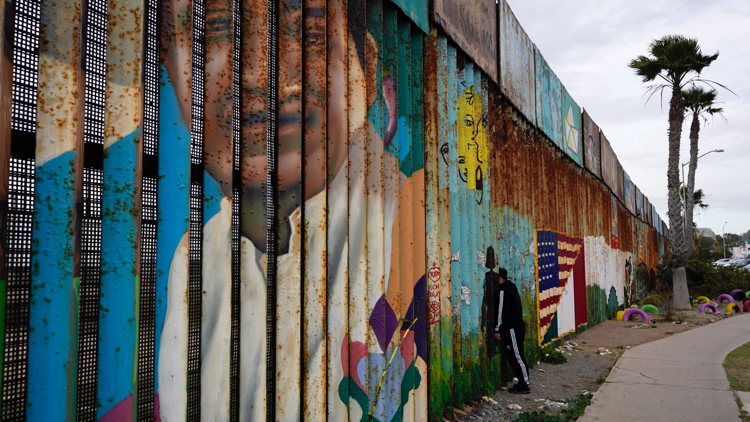 A man looks through the first wall at Friendship Park, near where the border separating Tijuana, Mexico, and San Diego meets the Pacific Ocean on Jan. 19, 2021, in Tijuana, Mexico. (Gregory Bull / Associated Press)