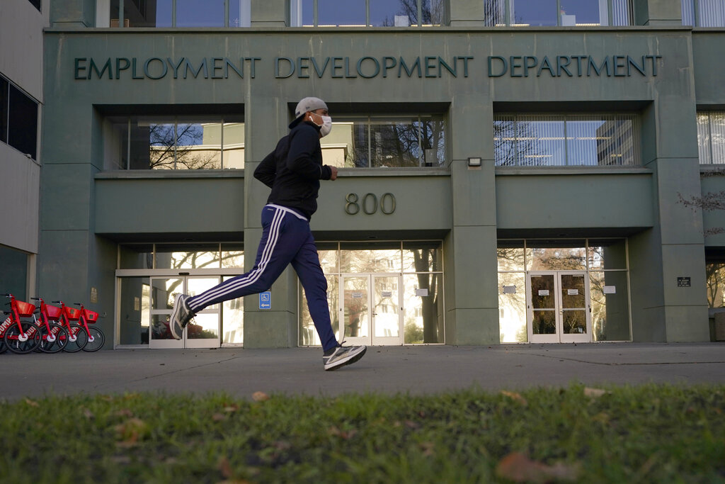 In his Dec. 18, 2020 file photo a runner passes the office of the California Employment Development Department in Sacramento. (AP Photo/Rich Pedroncelli, File)