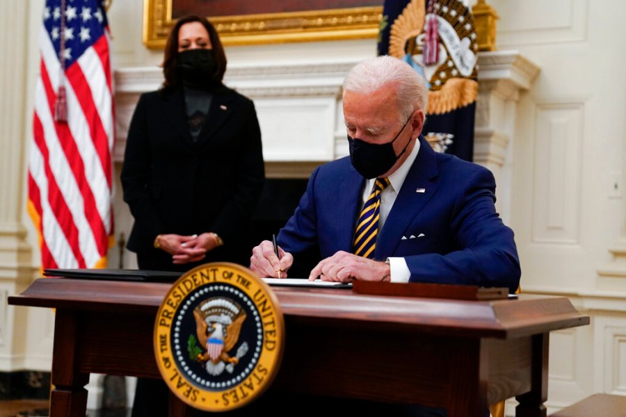 President Joe Biden signs executive orders on the economy in the State Dining Room of the White House, Friday, Jan. 22, 2021, in Washington. (AP Photo/Evan Vucci)