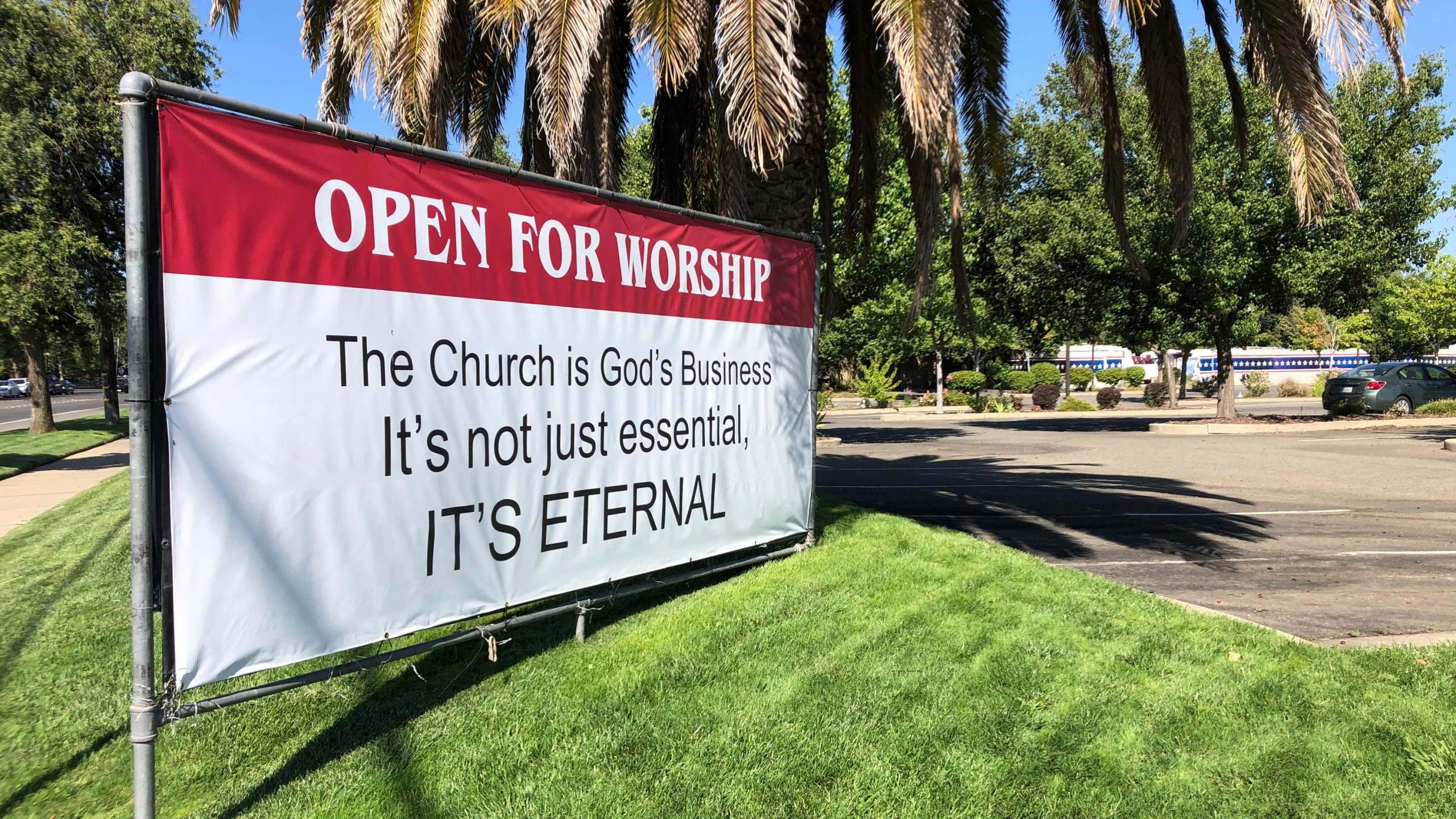 This July 9, 2020 file photo shows a banner reading: "Open for Worship, The Church is God's Business It's not just essential, It's Eternal," posted outside the Crossroads Community Church in Yuba City, Calif. (AP Photo/Adam Beam)