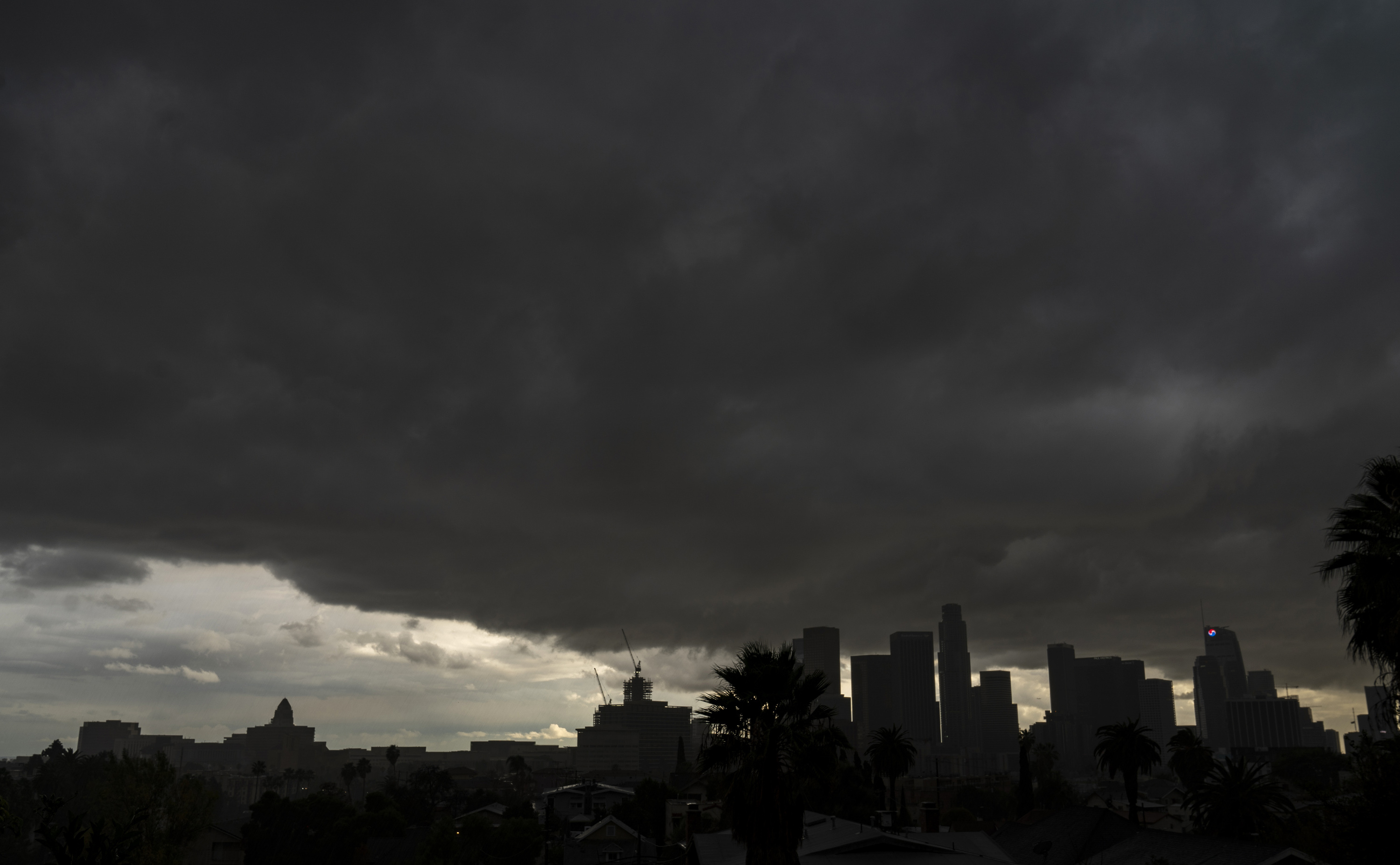 Heavy clouds move over the Los Angeles city skyline Saturday, Jan. 23, 2021. (AP Photo/Damian Dovarganes)