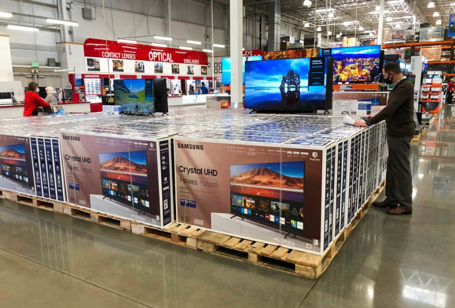 In this Nov. 10, 2020 photo, a shopper stands by a display of Samsung 65-inch televisions in a Costco warehouse in Sheridan, Colo. (AP Photo/David Zalubowski)