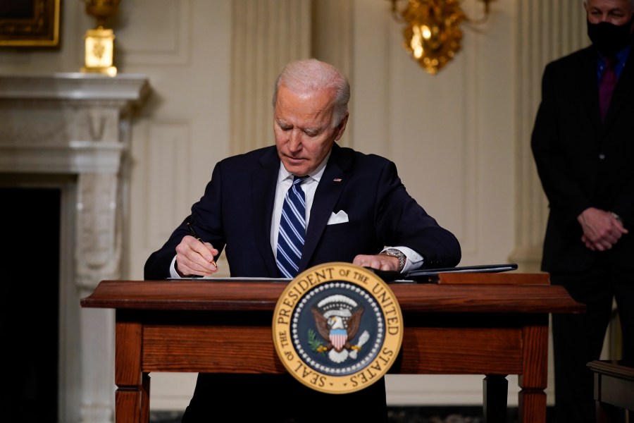 President Joe Biden signs an executive order on climate change in the State Dining Room of the White House on Jan. 27, 2021. (Evan Vucci / Associated Press)