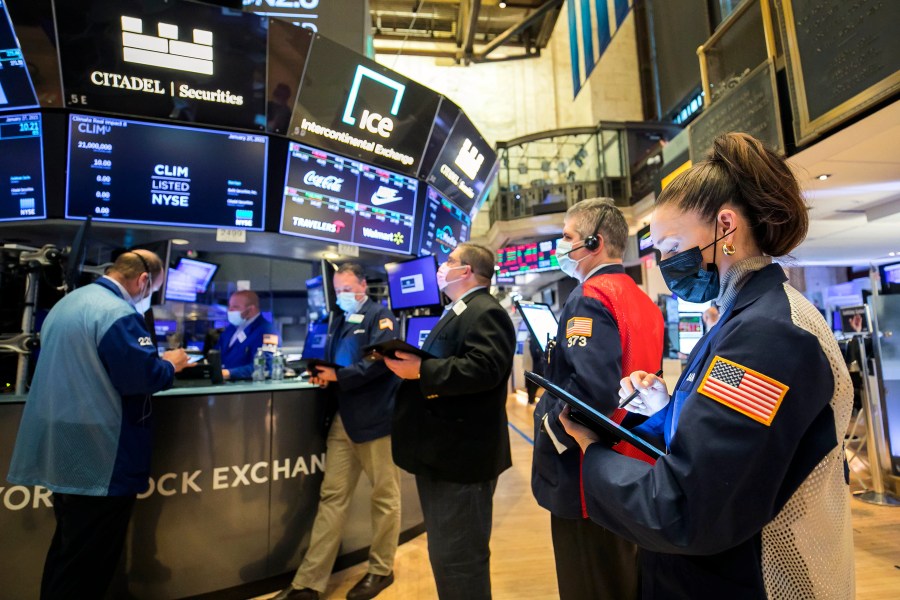 In this photo provided by the New York Stock Exchange, trader Samantha Tavares, right, works with colleagues on the floor, Wednesday, Jan. 27, 2021. Stocks were broadly lower in afternoon trading Wednesday, as investors focus on the outlook for the economy and corporate profits amid a still-raging coronavirus pandemic. (Courtney Crow/New York Stock Exchange via AP)