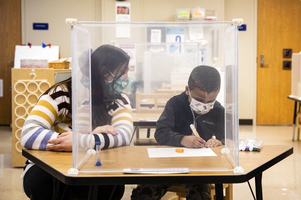 In this Jan. 11, 2021 file photo, pre-kindergarten teacher Sarah McCarthy works with a student at Dawes Elementary in Chicago. (Ashlee Rezin Garcia/Chicago Sun-Times via AP, Pool, File)