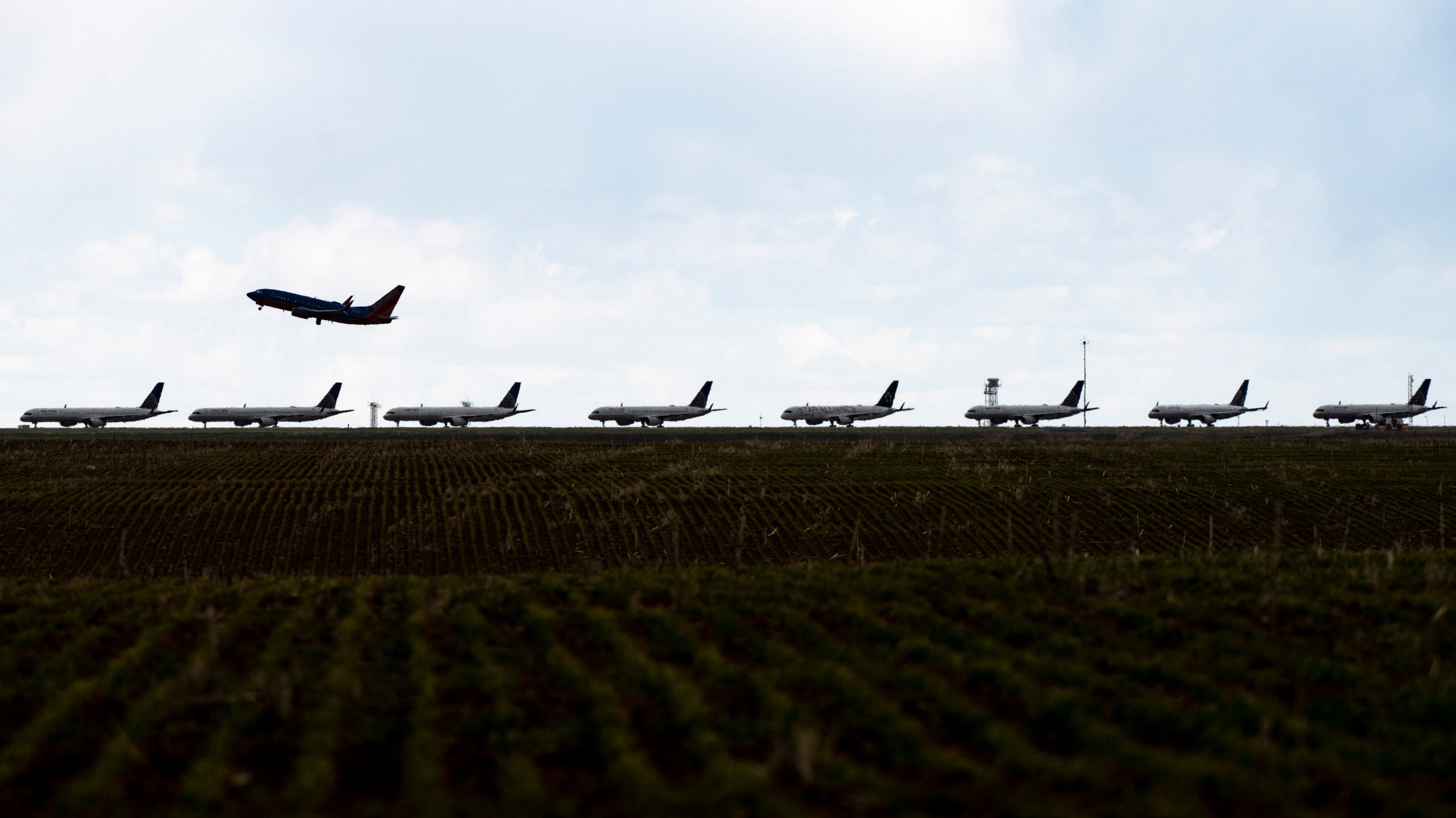 A Southwest Airlines flight takes off as United Airlines planes sit parked on a runway at Denver International Airport as the coronavirus pandemic slows air travel on April 22, 2020 in Denver, Colorado. (Photo by Michael Ciaglo/Getty Images)