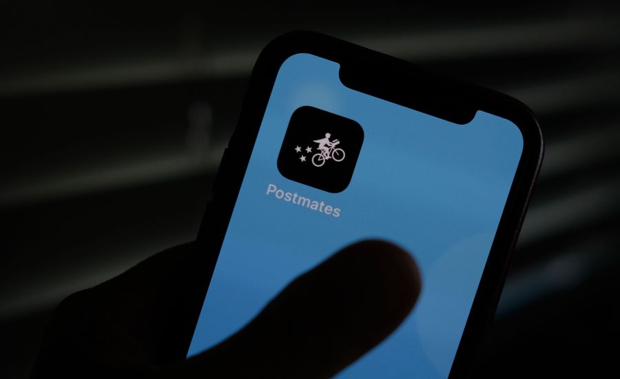 This illustration photo taken on June 30, 2020, shows the logo of delivery app Postmates on a smartphone screen in Los Angeles. (Chris Delmas / AFP / Getty Images)