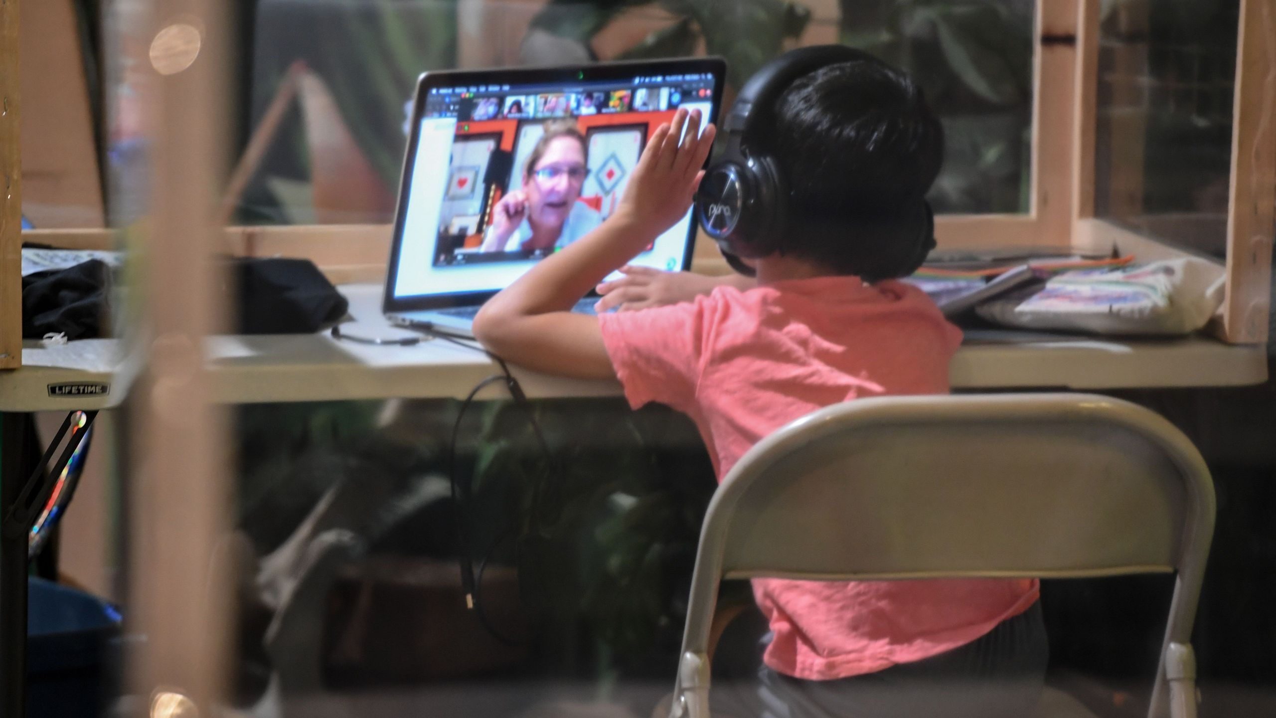 A student follows along remotely with their regular school teacher's online live lesson from a desk separated from others by plastic barriers at a tutoring center in Culver City on Sept. 10, 2020. (ROBYN BECK/AFP via Getty Images)