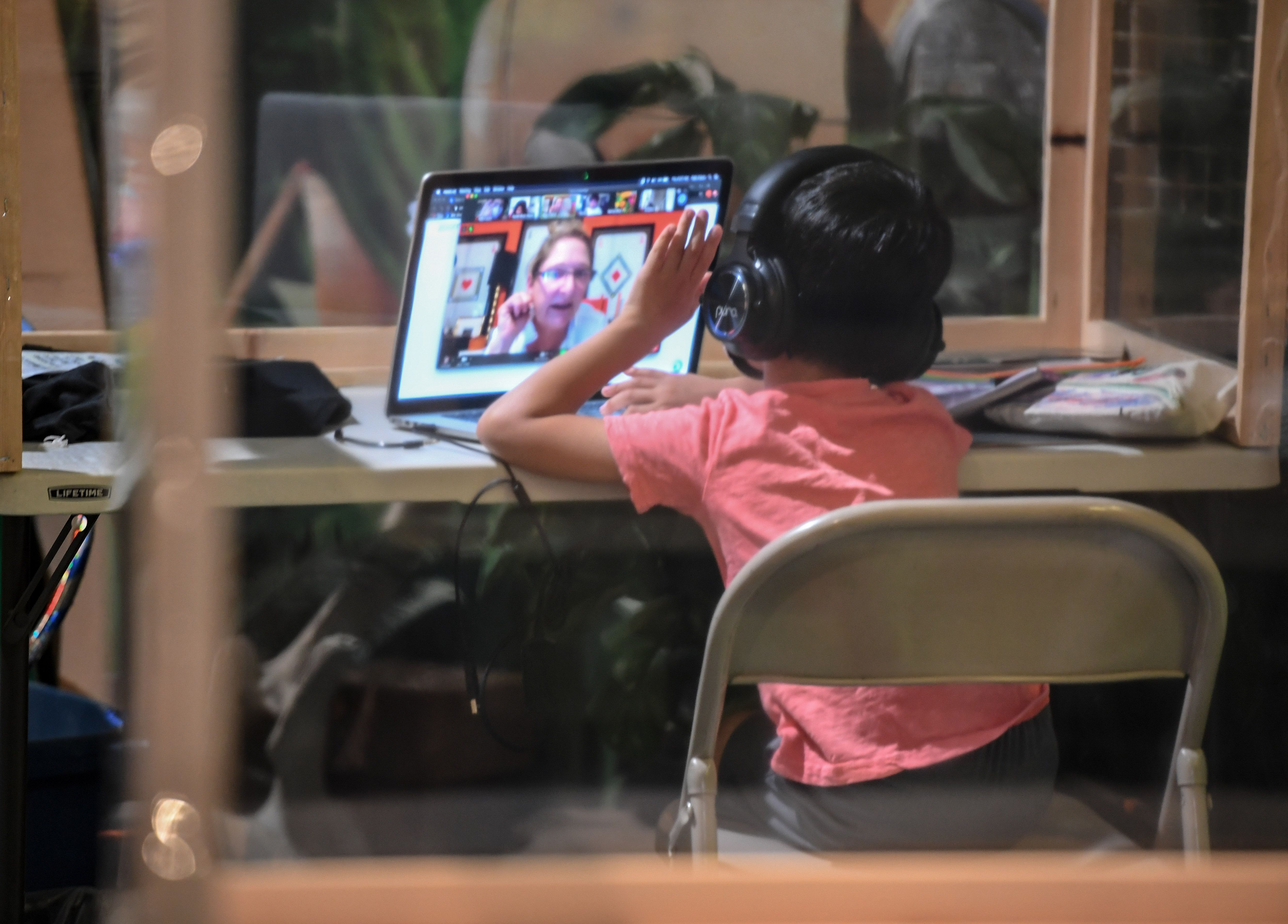 A student follows along remotely with their regular school teacher's online live lesson from a desk separated from others by plastic barriers at a tutoring center in Culver City on Sept. 10, 2020. (ROBYN BECK/AFP via Getty Images)