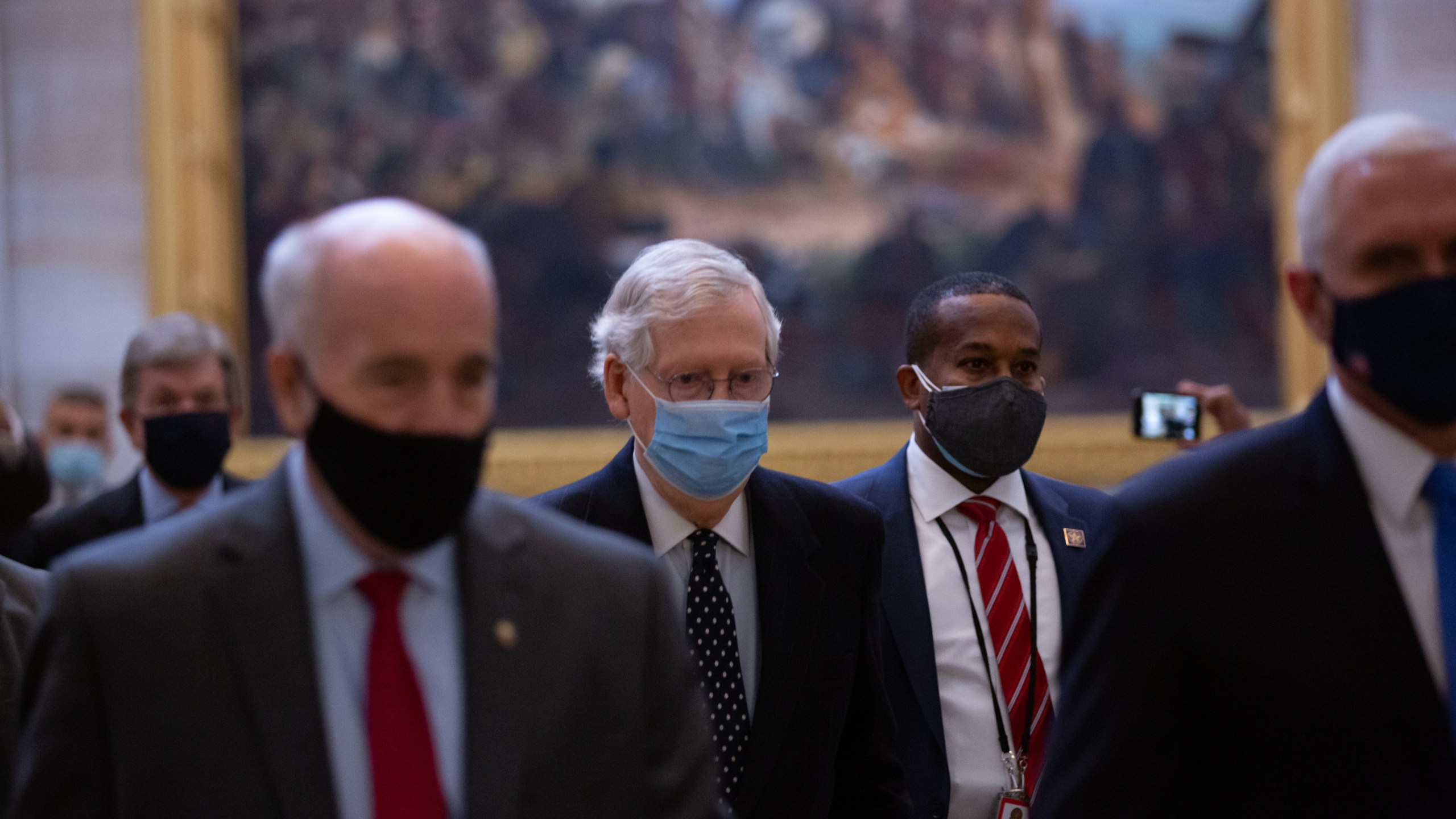 Senate Majority Leader Mitch McConnell, center, walks through the Rotunda headed to the House Chamber at the U.S. Capitol on Jan. 6, 2021. (Cheriss May / Getty Images)