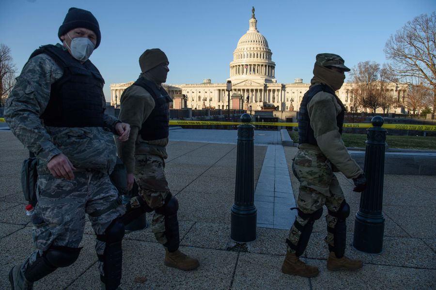 Members of the D.C. National Guard walk past the U.S. Capitol in Washington, D.C., on Jan. 7, 2020, one day after supporters of outgoing President Donald Trump stormed the building. (NICHOLAS KAMM/AFP via Getty Images)