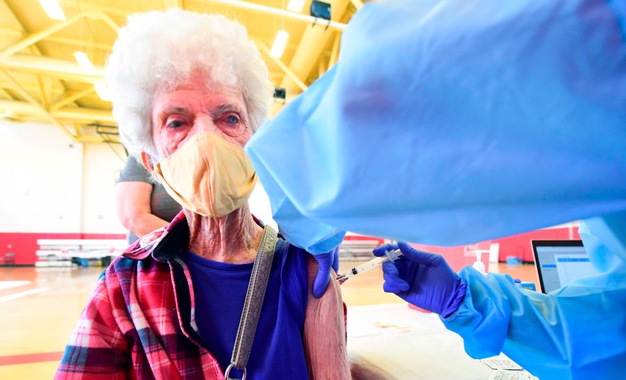 Beverly Goad, 89, receives her COVID-19 vaccine at the Corona High School gymnasium in the Riverside County city of Corona, California on January 15, 2021, a day after California began offering the coronavirus vaccine to residents 65 and older. (FREDERIC J. BROWN/AFP via Getty Images)