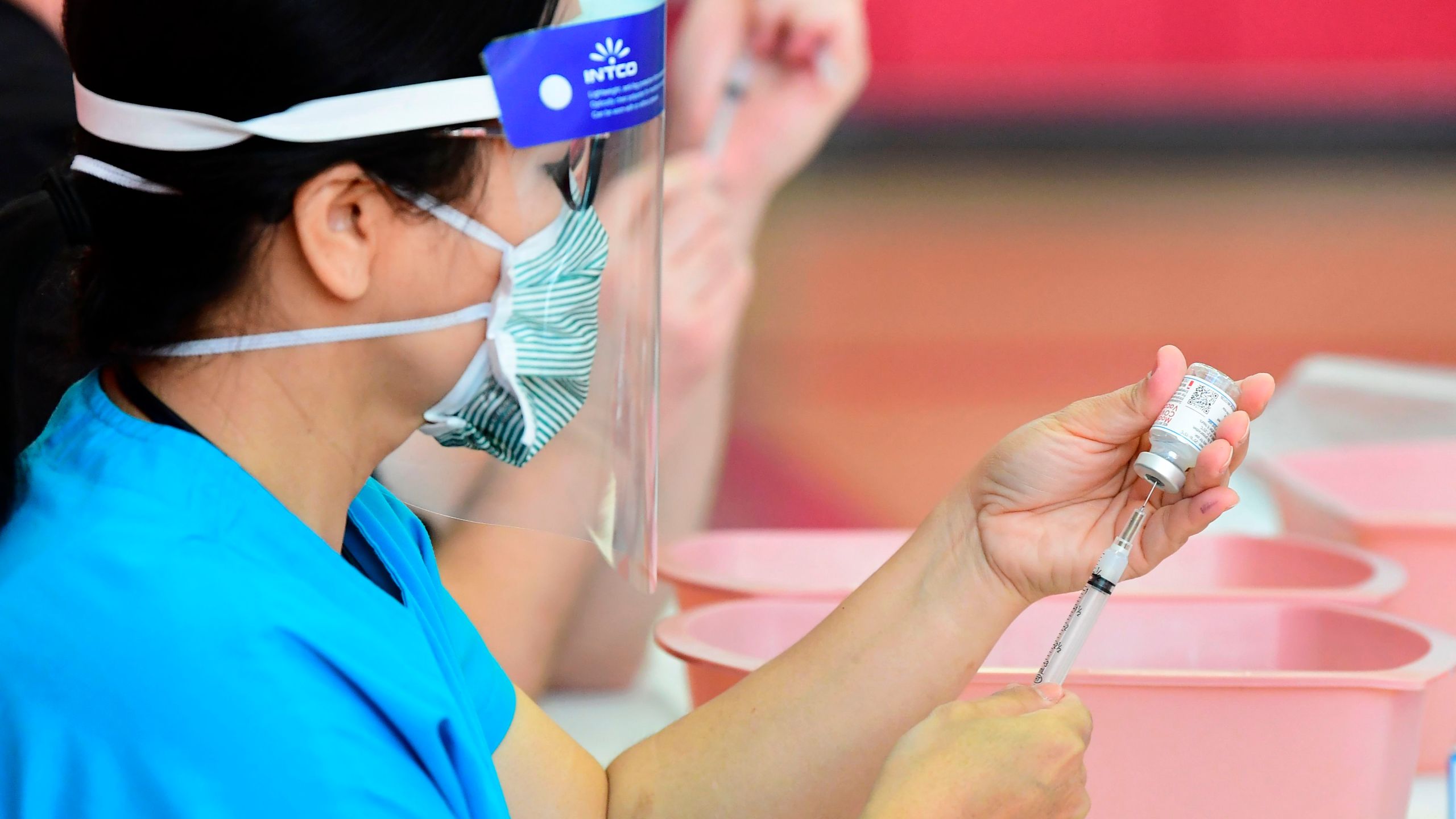 Registered nurses transfer the Moderna COVID-19 vaccine from a bottle into a syringe ready for vaccination at the Corona High School gymnasium in the Riverside County city of Corona, on Jan. 15, 2021. (FREDERIC J. BROWN/AFP via Getty Images)