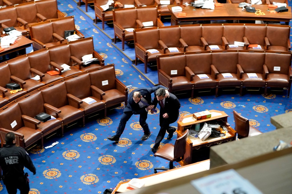 Members of Congress run for cover as protesters try to enter the House Chamber during a joint session of Congress on January 06, 2021 in Washington, DC. (Drew Angerer/Getty Images)