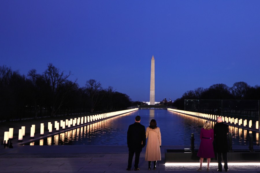 Doug Emhoff, Vice President-elect Kamala Harris, Jill Biden and President-elect Joe Biden face the Reflecting Pool as they observe a moment of silence at a memorial for victims of the coronavirus pandemic at the Lincoln Memorial on the eve of the presidential inauguration on Jan. 19, 2021, in Washington, D.C. (Michael M. Santiago/Getty Images)