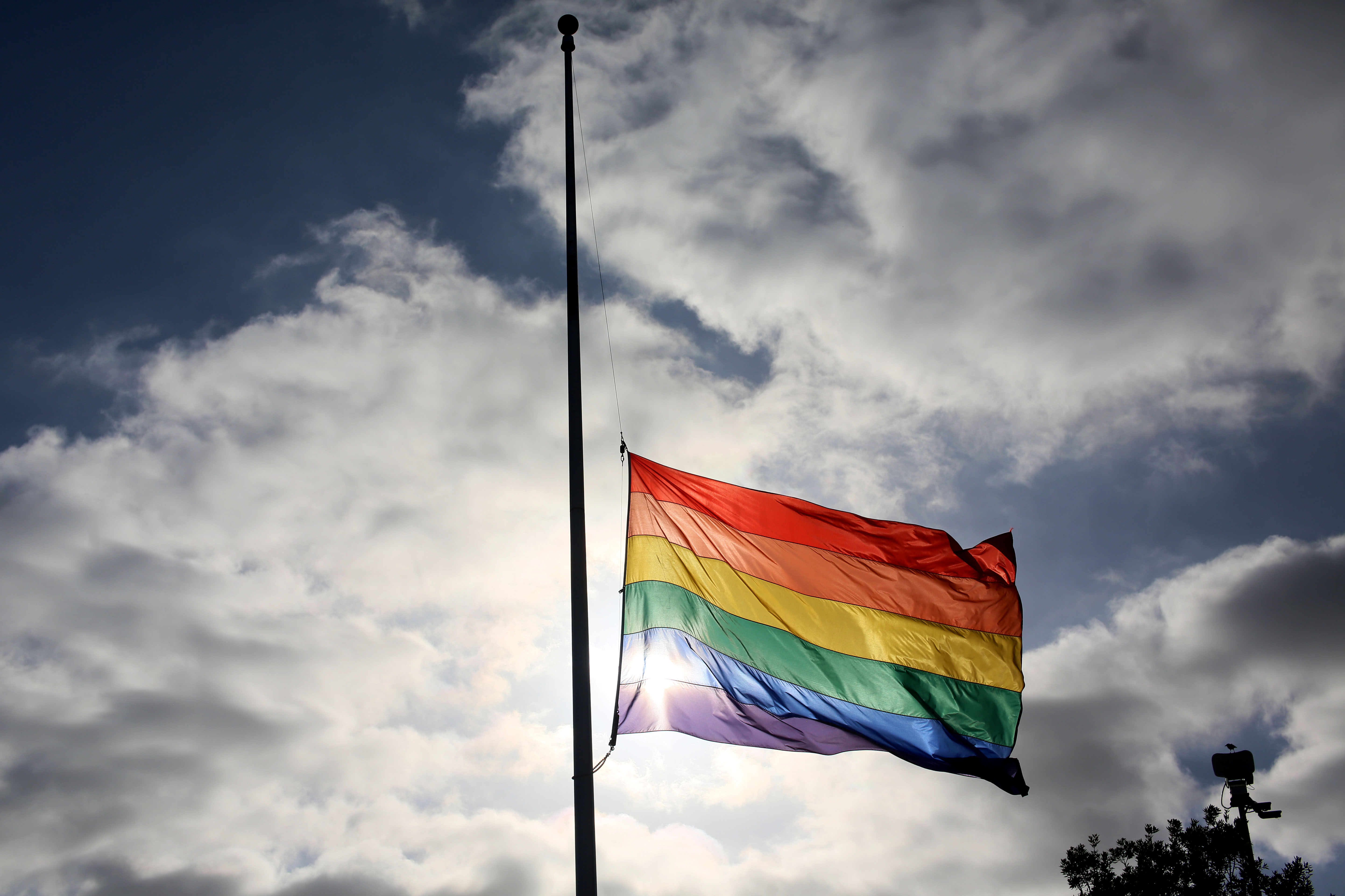 A pride flag stands a half mast during a memorial service in San Diego, California on June 12, 2016, for the victims of the Orlando Nighclub shooting.(Sandy Huffaker/AFP via Getty Images)