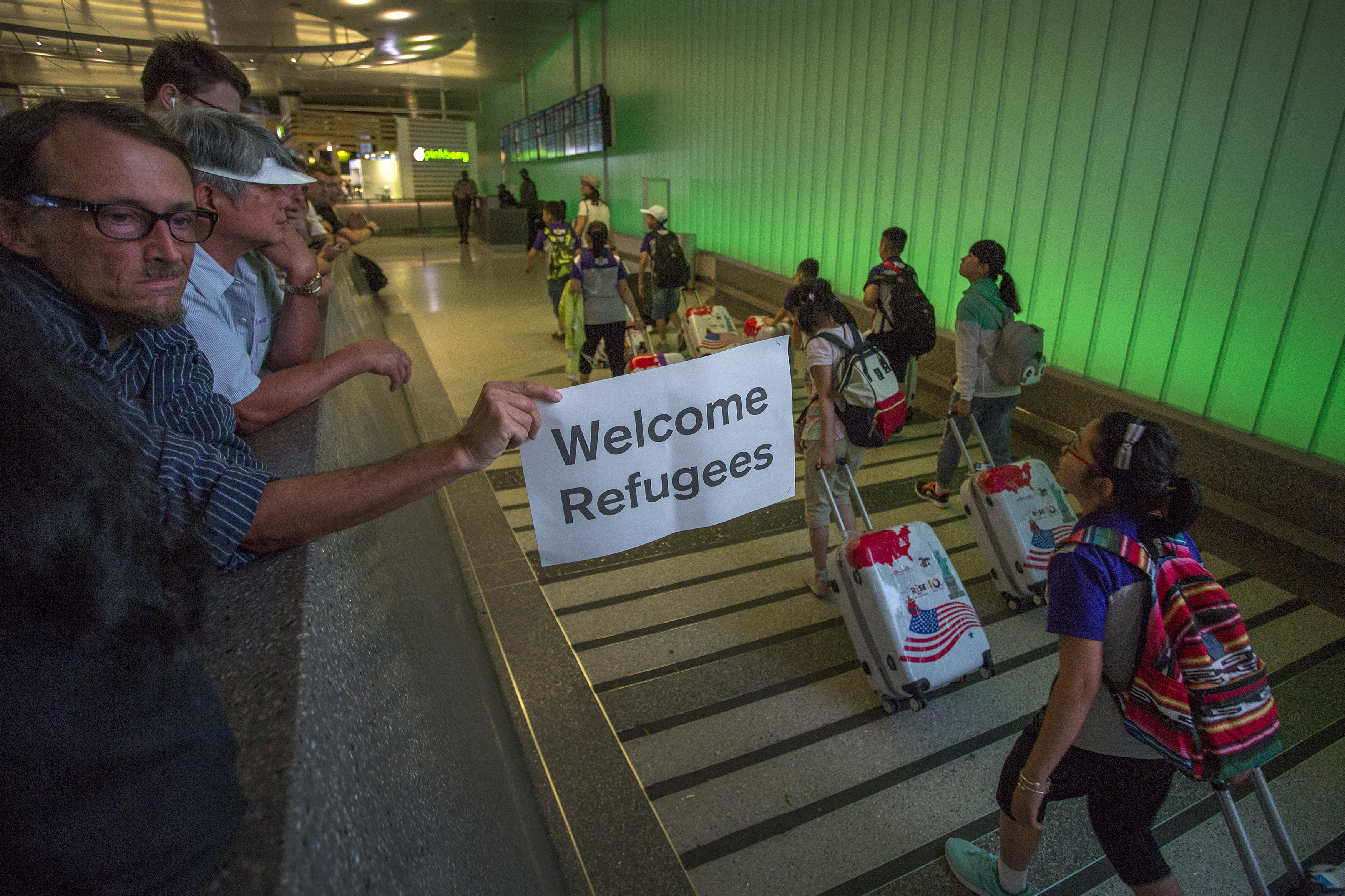 This file photo from June 29, 2017 shows a man carrying a welcome sign as international travelers arrive at LAX on the first day of the the partial reinstatement of the Trump travel ban, temporarily barring travelers from six Muslim-majority nations from entering the U.S. (David McNew/Getty Images)