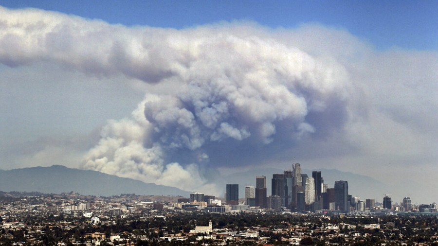 In this Monday, June 20, 2016 file photo, smoke from wildfires burning in Angeles National Forest fills the sky behind the Los Angeles skyline. (AP Photo/Ringo H.W. Chiu)