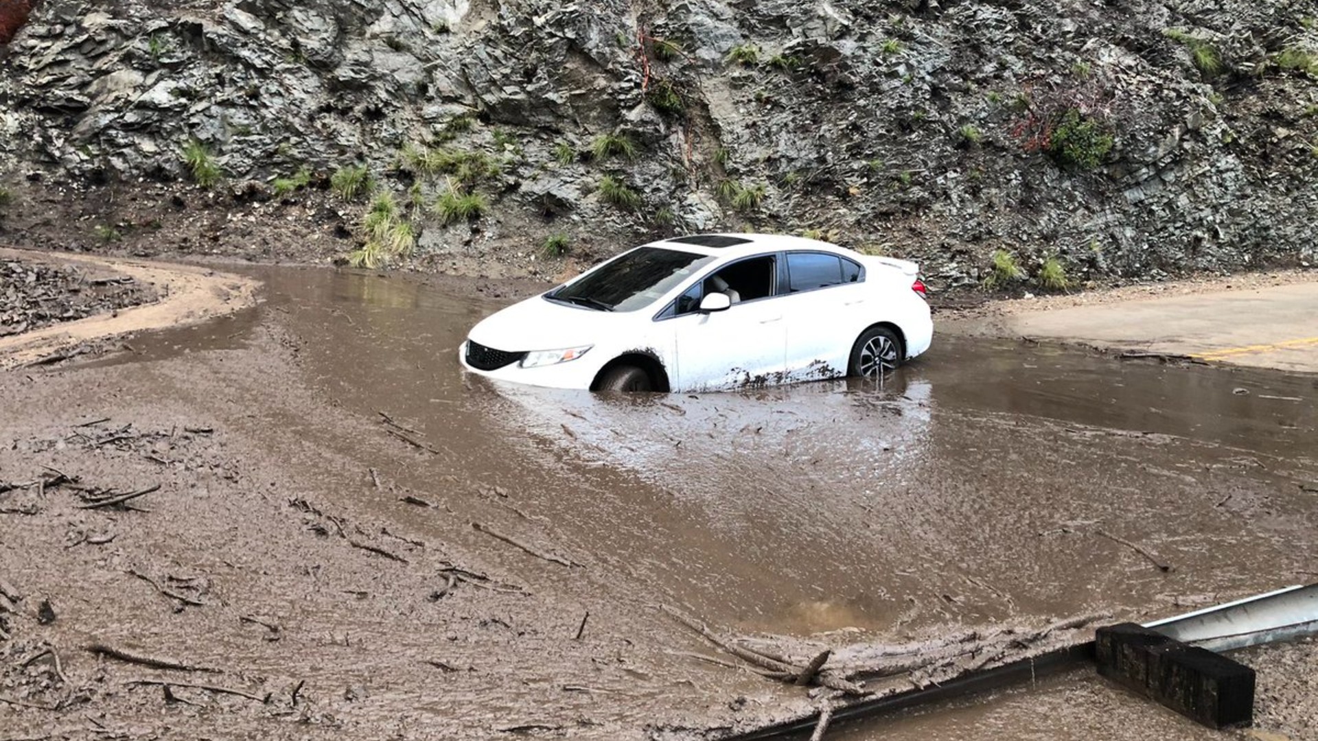 A car is stuck in the mud following a mudslide above Azusa on Jan. 29, 2021. (KTLA)