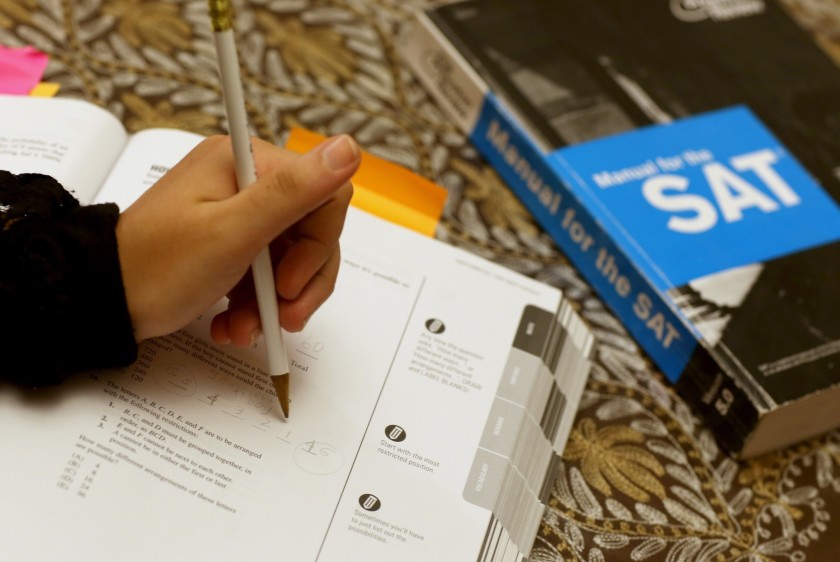 A file photo shows a student writing on an SAT practice workbook. (Joe Raedle / Getty Images)