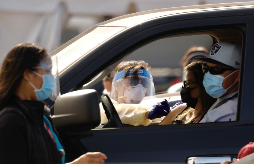 Drivers pull up to a mass vaccination site in the parking lot of the Forum in Inglewood. (Al Seib / Los Angeles Times)