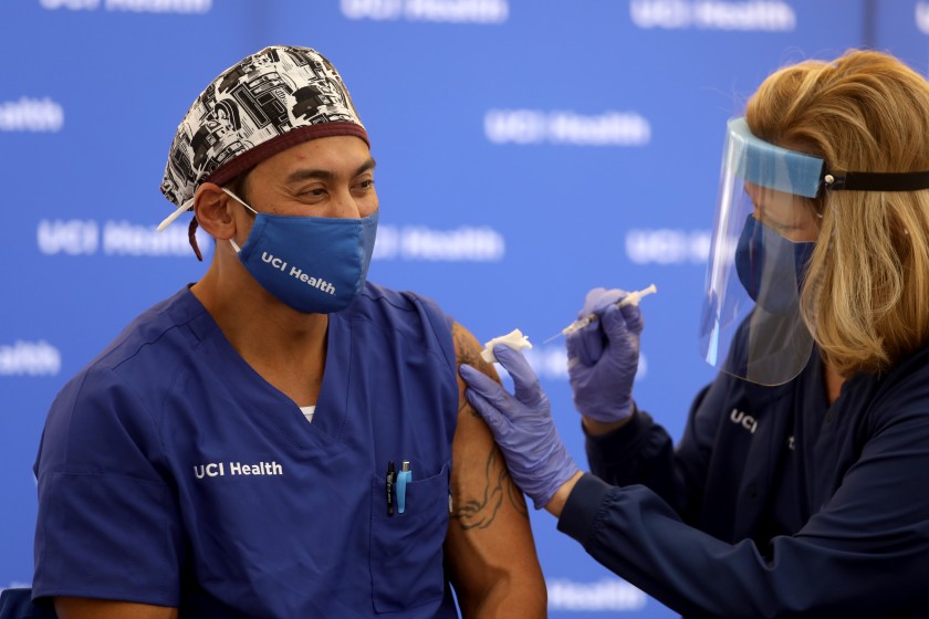 Erik Mara, a respiratory therapist at UCI Health, receives a Pfizer BioNTech COVID-19 vaccine on Dec. 16 in Orange. (Gary Coronado / Los Angeles Times)